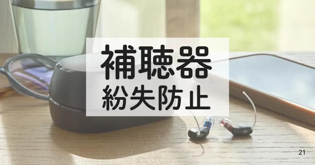 机の上に補聴器、スマホ、コップの写真。写真前面に「補聴器 紛失防止」の字